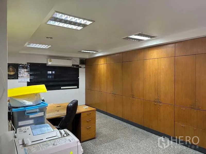 Factory for rent or sale in Bang Phli, Samut Prakan - Office room with long wall of wooden built-in cabinets, desk and ceiling lighting.