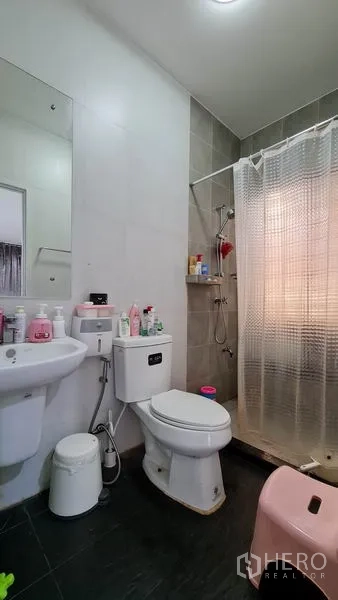 Detached House for sale in Samut Prakan - Compact bathroom with shower area, toilet and sink.