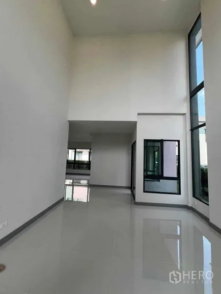 独立式住宅 出租在Khlong Sam Wa, Bangkok - 室内挑高双层大厅，高窗与极简白墙。