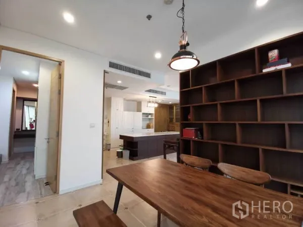 公寓 出租或出售在Bang Rak, Bangkok - 开放式餐区，吊灯、巨型木质书架，与现代中岛厨房相连。