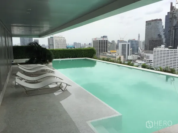 Condominium for rent in Bang Rak, Bangkok - Rooftop infinity-edge swimming pool with sun loungers and Bangkok skyline views.