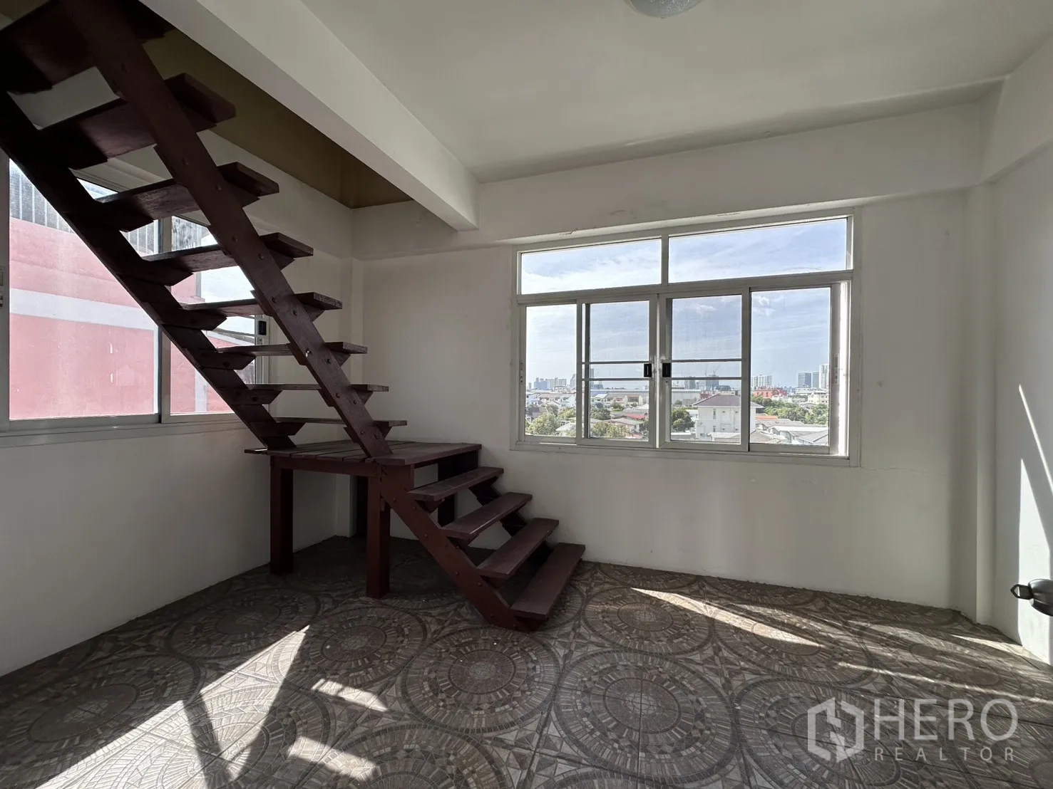 Shophouse for rent in Phra Khanong, Bangkok - Room with wooden stairs to an upper platform and large windows.