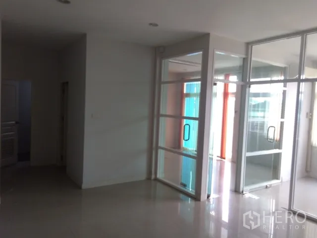 Factory for sale in Lam Luk Ka, Pathum Thani - Entrance corridor with sliding glass doors leading to partitioned offices.
