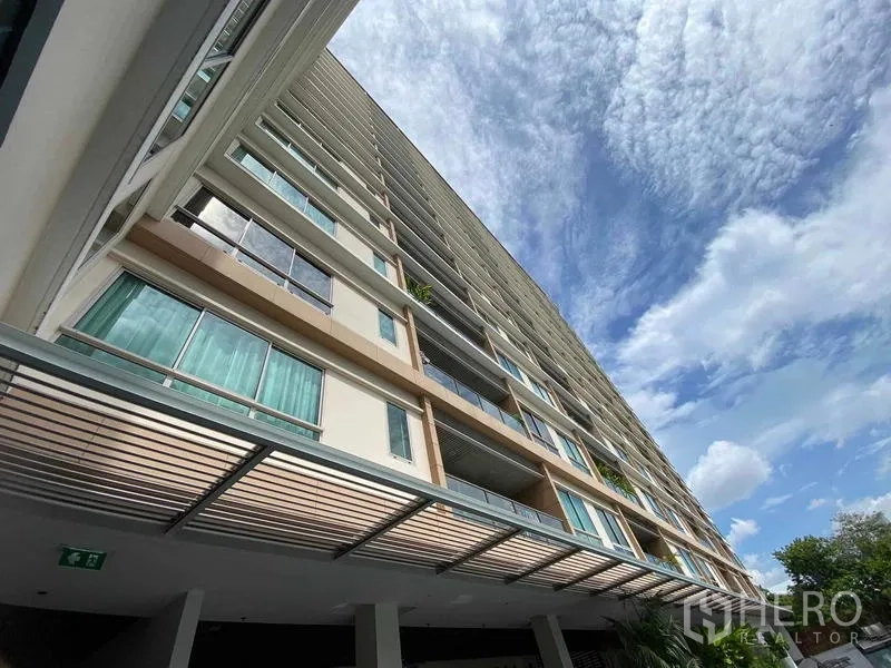 公寓 出租在Yan Nawa, Bangkok - 自下而上仰視高層公寓外立面與藍天白雲。