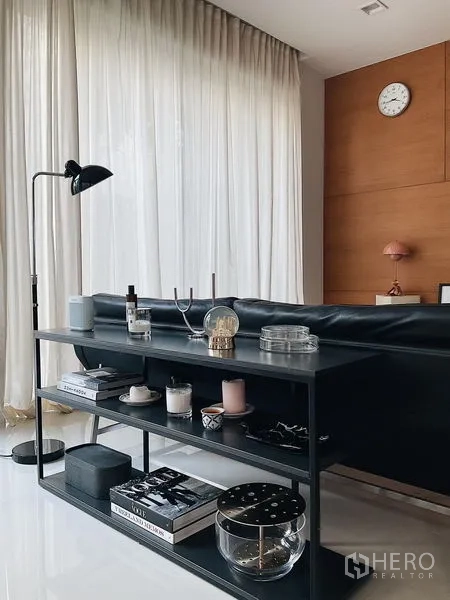 Detached House for sale in Bang Kapi, Bangkok - Black metal console and sofa set against full-height curtains in the living area.