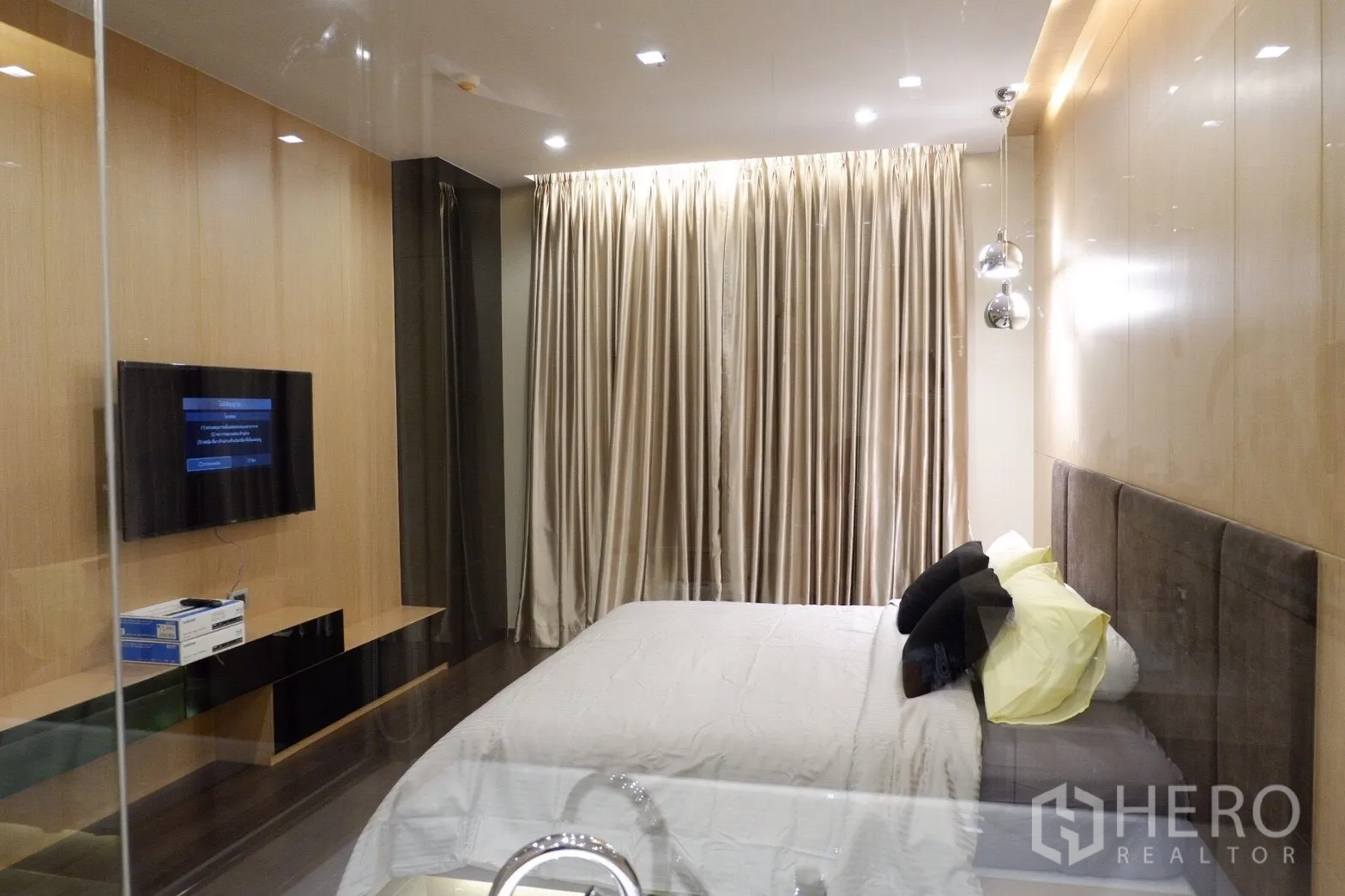 คอนโด ให้เช่าในWatthana, Bangkok - มุมมองห้องนอนพร้อมทีวีติดผนัง ผ้าม่านทึบยาว ตู้วางของบิวท์อิน และแสงไฟอบอุ่น