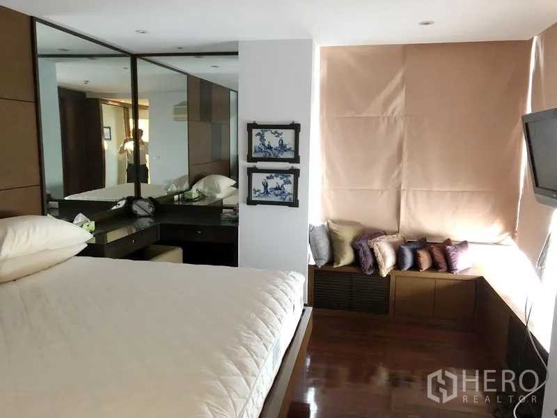 คอนโด ให้เช่าในWatthana, Bangkok - ห้องนอนหลักสว่างพร้อมม้านั่งริมหน้าต่าง ตู้เสื้อผ้าบานกระจก และพื้นไม้