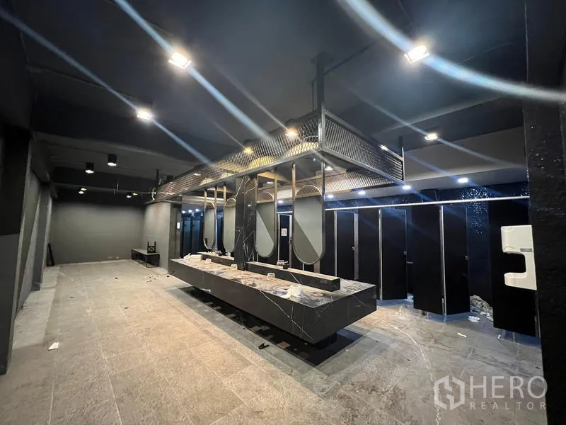 Showroom for rent in Mueang Samut Prakan, Samut Prakan - Modern restroom with suspended mirrors above black stone counter and stalls