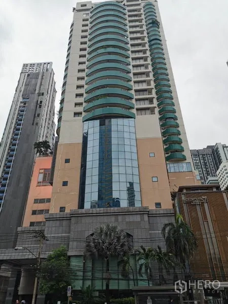 公寓 出租在Watthana, Bangkok - Las Colinas 公寓高层外观，绿色弧形阳台与玻璃立面。