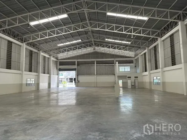 โรงงาน ให้เช่า - ภายในอาคารอุตสาหกรรมแบบไร้เสากลาง ไฟสว่าง และประตูม้วนหลายจุด