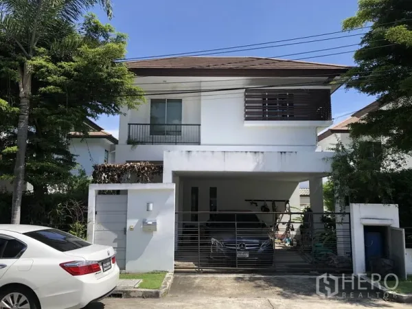 独立式住宅 出租或出售在Saphan Sung, Bangkok - 曼谷沙攀颂区两层白色独栋住宅，带大门车棚与绿树。