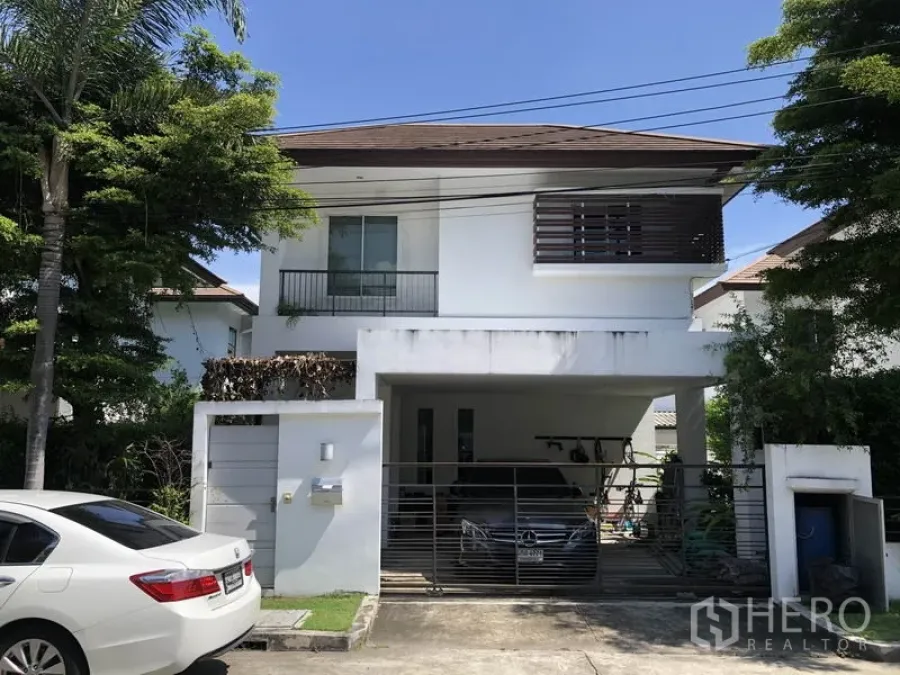 Detached House for rent or sale in Saphan Sung, Bangkok - Two-storey white detached house with gated carport and mature trees in Saphan Sung, Bangkok.
