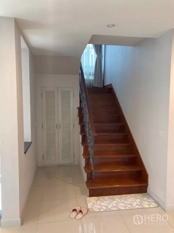 Detached House for rent in Mueang Nonthaburi, Nonthaburi - Wooden staircase with storage closet below leading up to the second floor.