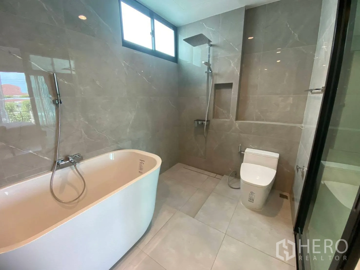 Townhouse for rent in Bang Kapi, Bangkok - Contemporary bathroom with a freestanding bathtub, rain shower, and grey marble-look tiles.
