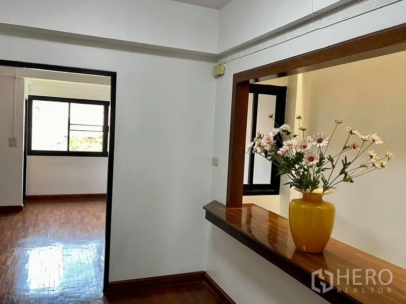 Home Office for rent in Khlong Toei, Bangkok - Hallway niche with a wooden ledge and interior window opening to another bright room.