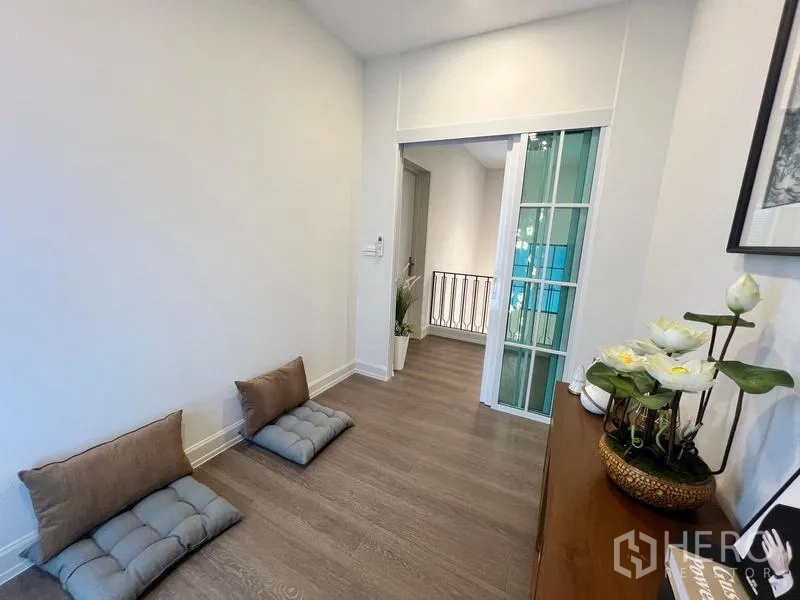 Detached House for rent or sale in Saphan Sung, Bangkok - Small upstairs sitting area with floor cushions beside a sliding glass door.