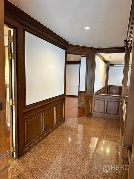 Condominium for rent in Bangkok - Wood-trimmed corridor connecting rooms with glossy stone flooring.