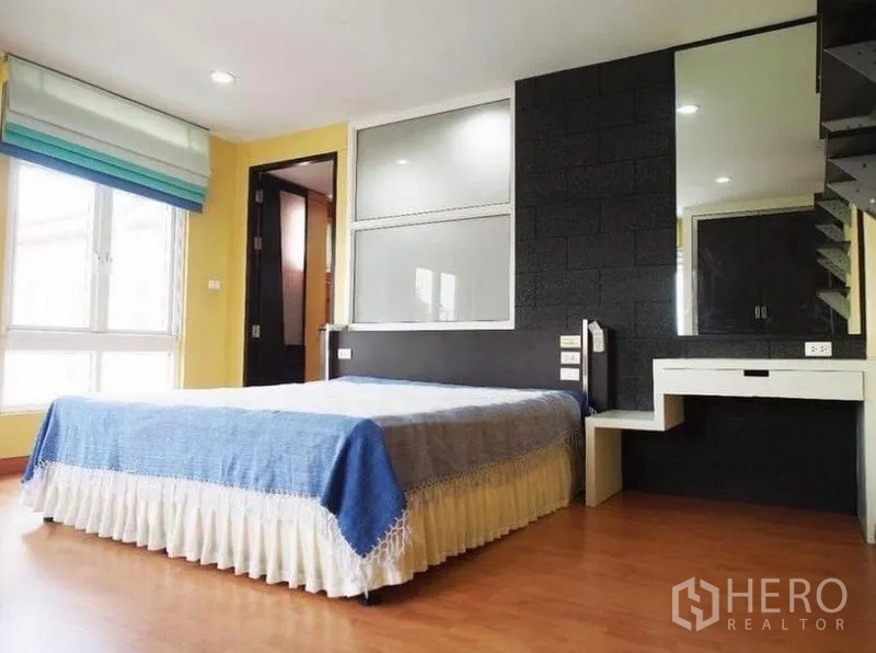 联排别墅 出租在Wang Thonglang, Bangkok - 采光充足的卧室，超大窗户，黑色点缀墙，梳妆台与木地板。