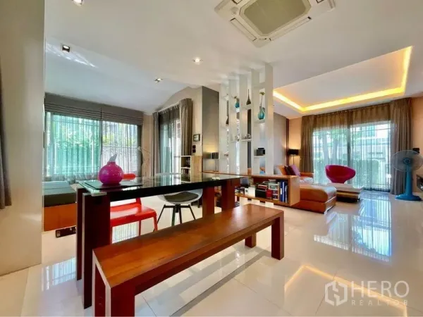 独立式住宅 出售在Prawet, Bangkok - 明亮的开放式餐客区，玻璃餐桌、长凳座位与氛围灯带。