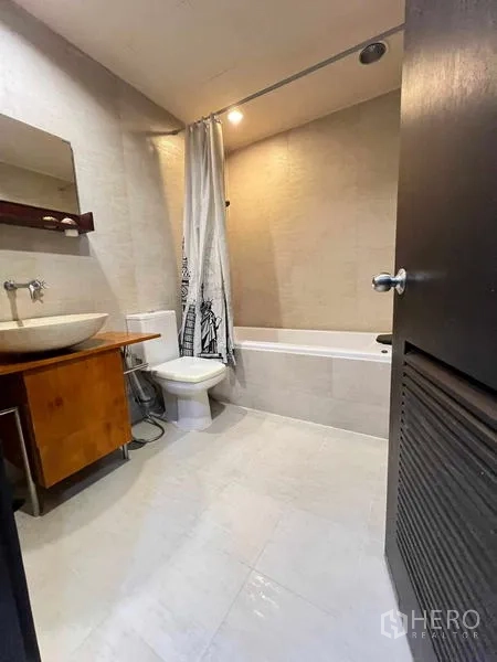 公寓 出租在Ratchathewi, Bangkok - 现代浴室，设浴缸、台上盆与中性色墙砖。
