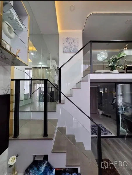 公寓 出租在Chatuchak, Bangkok - 玻璃扶手楼梯通往夹层，镜面墙与内置展示架。