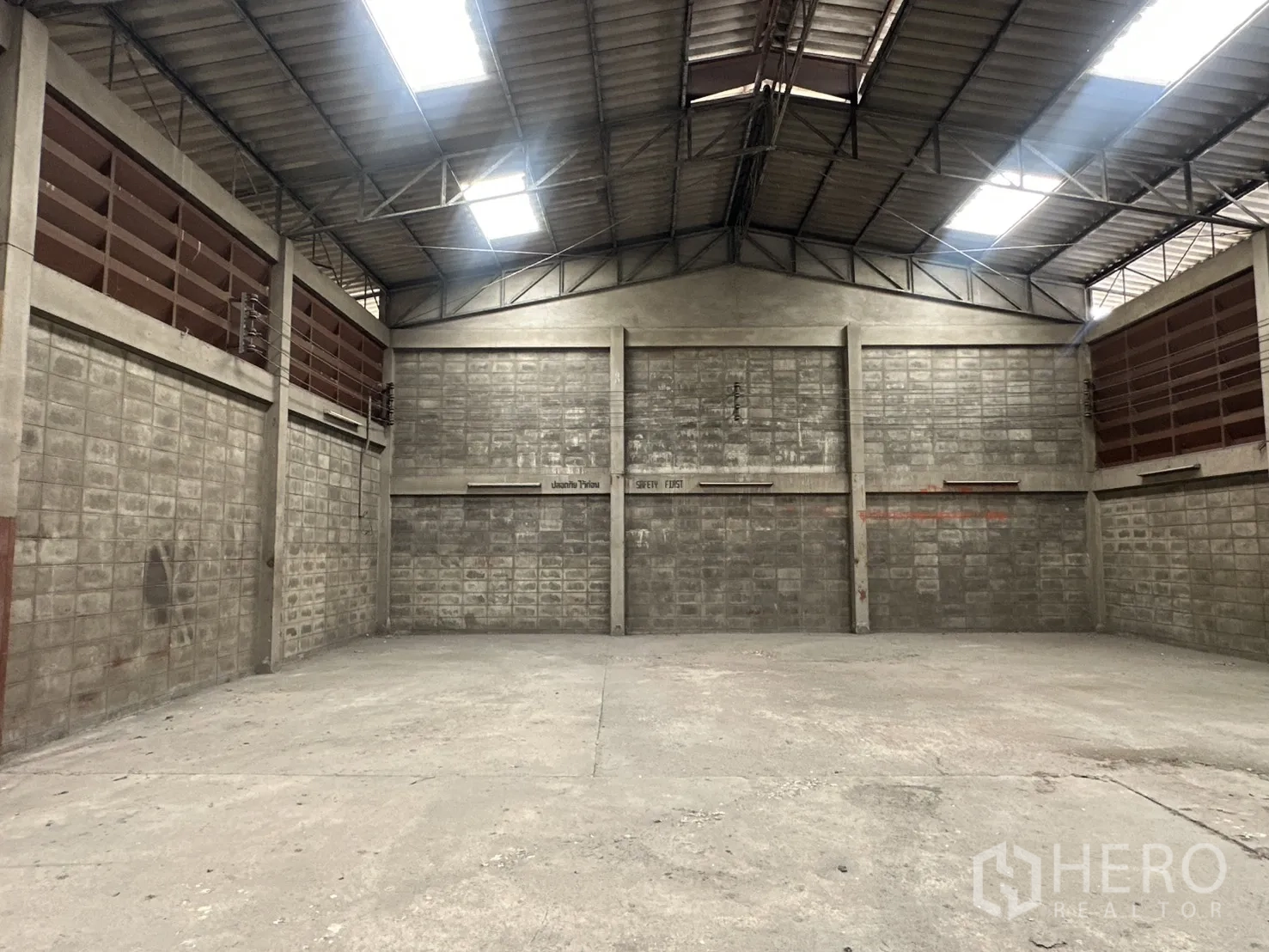 Warehouse for rent in Phra Khanong, Bangkok - Open warehouse hall with high gabled roof and skylights.
