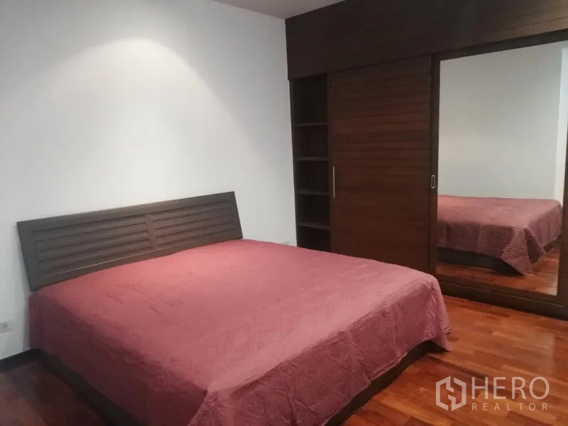 公寓 出租在Watthana, Bangkok - 宽敞卧室，木地板，特大床与镜面衣柜。