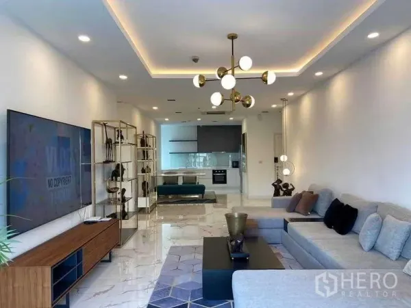 公寓 出租或出售在Watthana, Bangkok - 通罗Noble Aura现代客厅，L形沙发、仿大理石地面与开放式厨房。