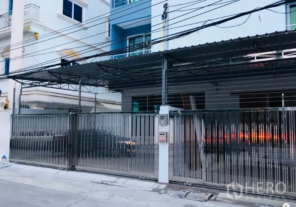 Townhouse for rent in Huai Khwang, Bangkok - Gated townhouse exterior with wide metal sliding gate and covered carport in Huai Khwang.
