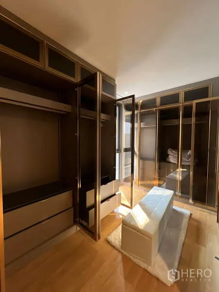 Detached House for rent in Suan Luang, Bangkok - Walk‑in closet with glass‑front wardrobes and center bench.