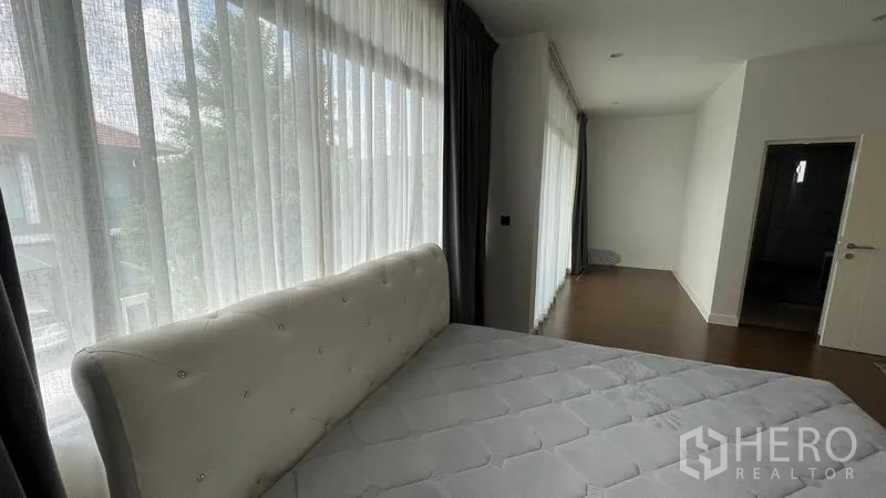 Detached House for rent in Bang Kapi, Bangkok - Master bedroom beside full-height sheer curtains with garden outlook.