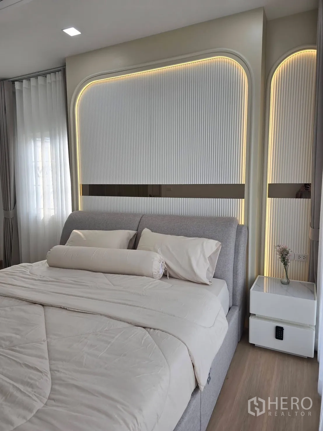 Semi-detached House for rent in Mueang Samut Prakan, Samut Prakan - Master bedroom with upholstered bed, LED-lit feature headboard and bedside table.