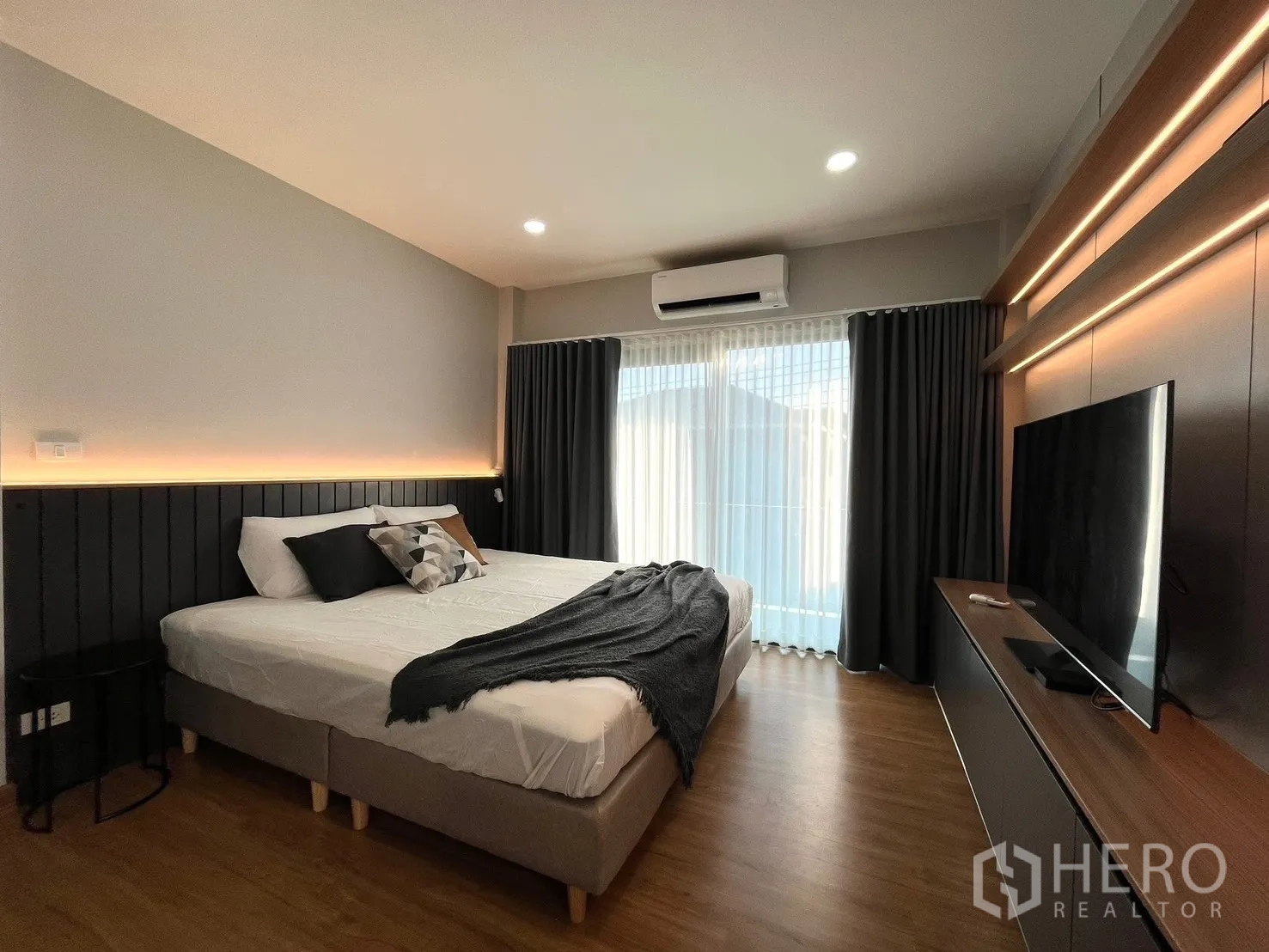 Detached House for rent in Bang Phli, Samut Prakan - Large bedroom with backlit headboard, TV console and floor-to-ceiling curtains.