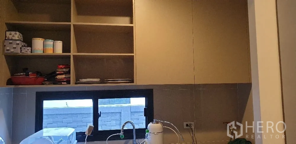 Detached House for rent or sale in Lam Luk Ka, Pathum Thani - Kitchen storage with open shelving and window over sink.