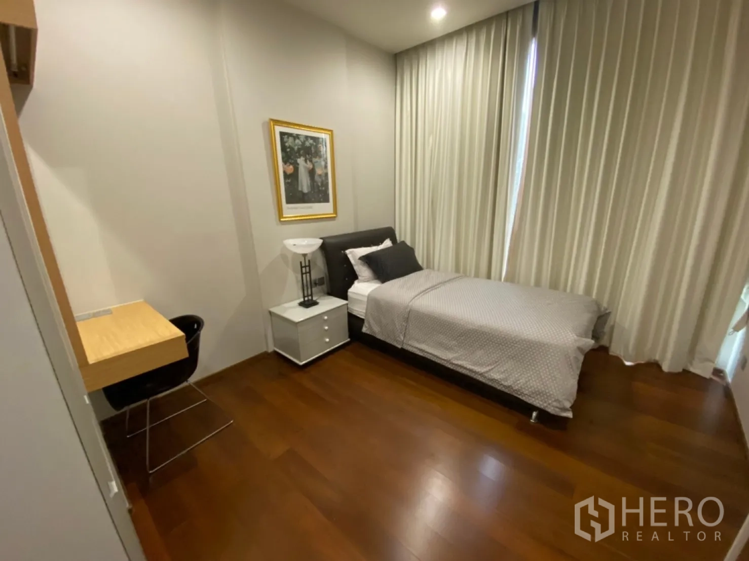 公寓 出租在Watthana, Bangkok - 次卧配单人床、书桌、床头柜与落地窗帘。