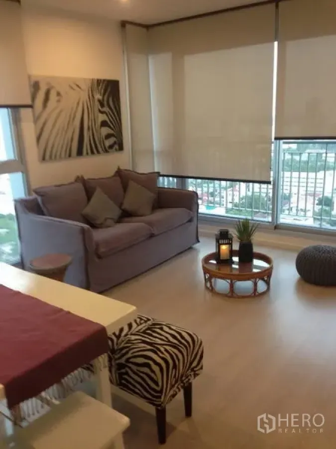 คอนโด ให้เช่าในSathon, Bangkok - ห้องนั่งเล่นสว่างของคอนโด Rhythm Sathorn พร้อมโซฟา ระเบียง และวิวเมืองผ่านหน้าต่างบานใหญ่.
