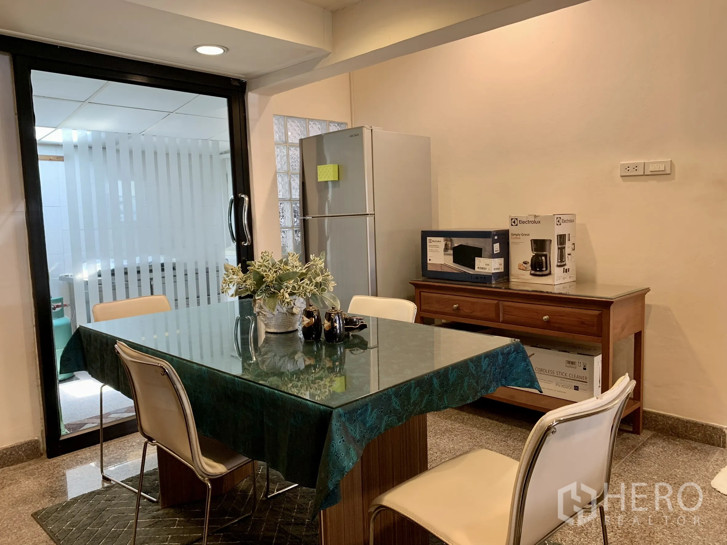独栋房屋 for rent in Saphan Sung, Bangkok - 餐区设玻璃台餐桌、四把椅子、冰箱与木质边柜。