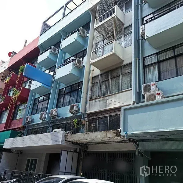 Shophouse for rent in Khlong Toei, Bangkok - Facade of multi-storey shophouse row with balconies and air-conditioning units.