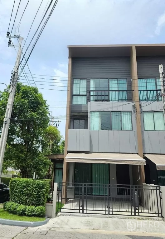 Townhouse for rent in Saphan Sung, Bangkok - Modern three-storey corner townhouse with gated carport and garden frontage.