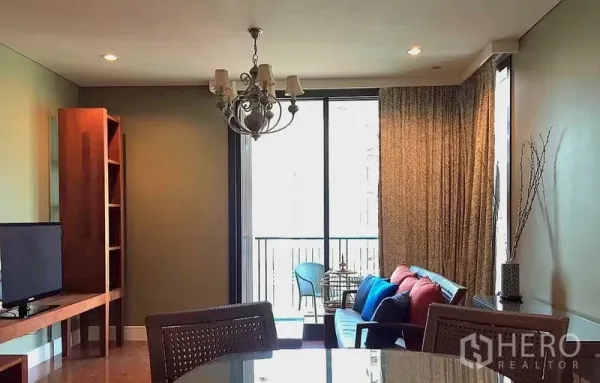 公寓 出租在Khlong Toei, Bangkok - 客厅另一视角，吊灯、座位区与通往阳台的玻璃门。