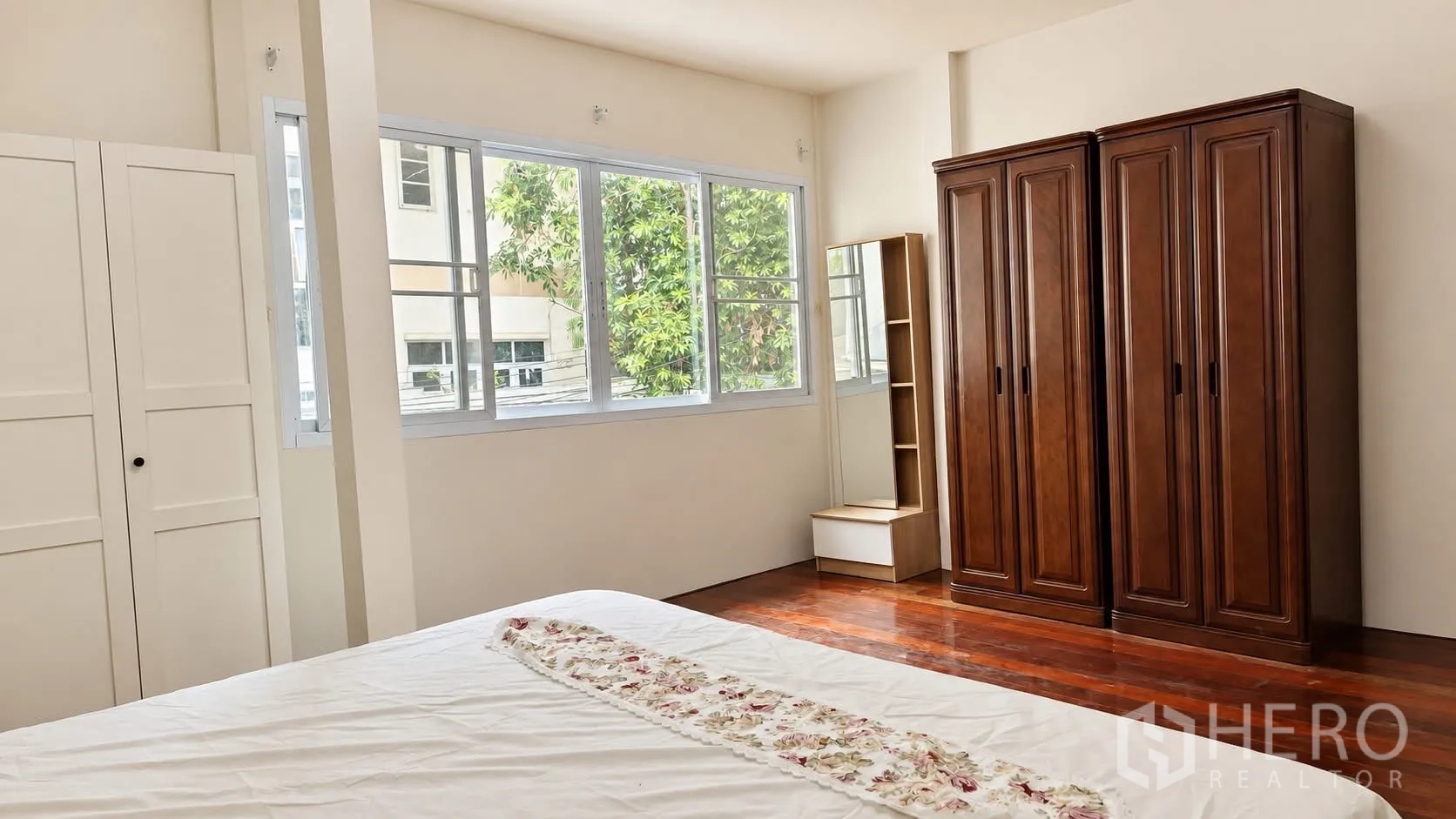บ้านเดี่ยว for rent in Khlong Toei, Bangkok - ห้องนอนสว่างด้วยหน้าต่างบานใหญ่ พื้นไม้ และตู้เสื้อผ้า