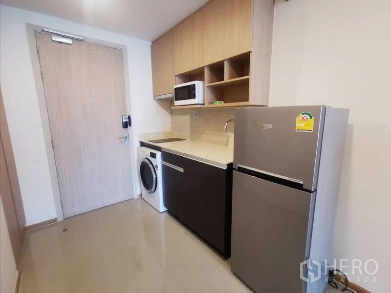 Condominium for rent in Ratchathewi, Bangkok - Compact kitchenette with refrigerator, microwave and washing machine.