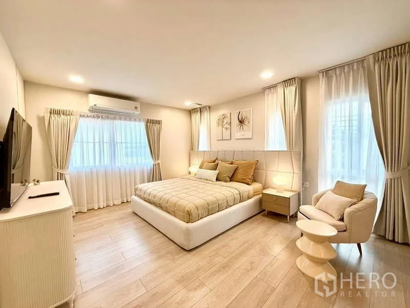Detached House for rent in Bang Phli, Samut Prakan - Master bedroom angle showing large bed, TV cabinet and windows.