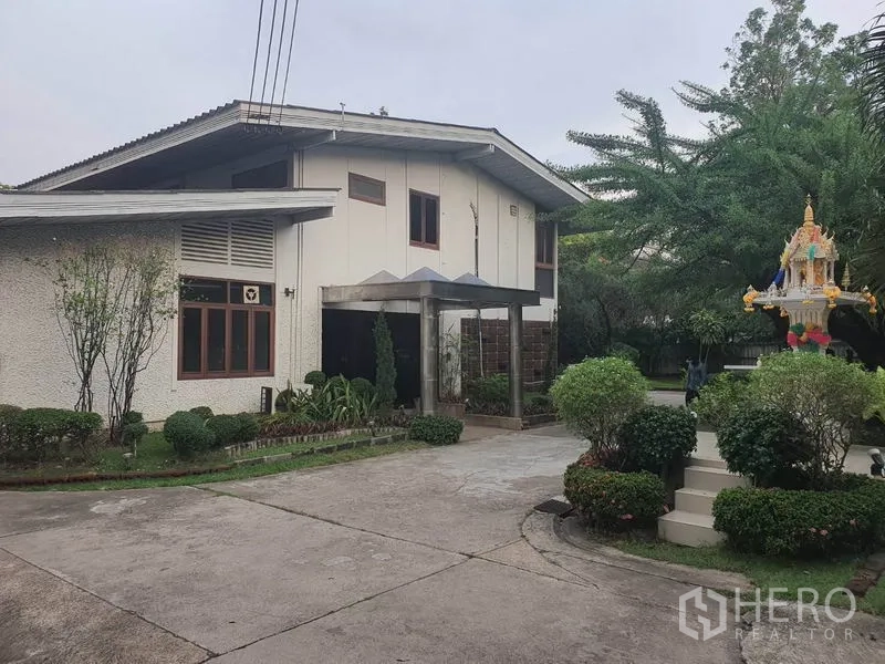 Home Office for rent in Watthana, Bangkok - Angled view of main entrance with landscaped garden and mature trees