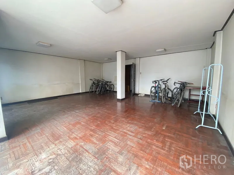 Retail Space for rent in Watthana, Bangkok - Spacious room with parquet floors and white walls, ideal for showroom or office use.