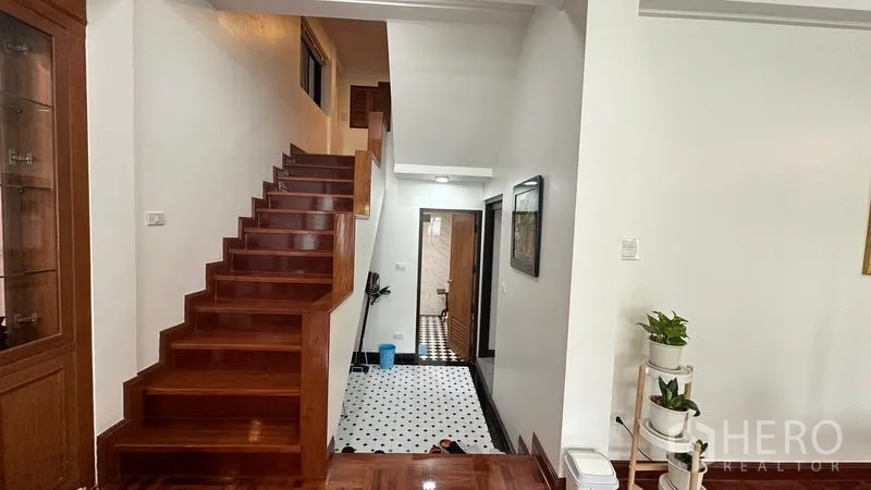 独立式住宅 出租在Watthana, Bangkok - 从客厅通往下层的楼梯，入口处黑白地砖。