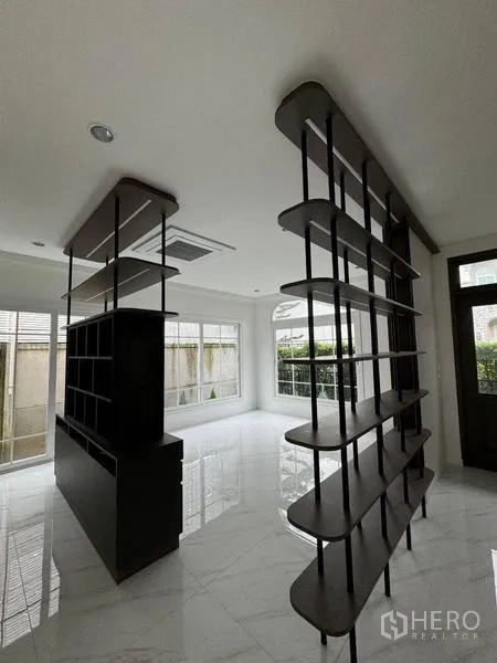 บ้าน ให้เช่า - ห้องนั่งเล่นสว่าง พื้นลายหินอ่อน และฉากชั้นวางโปร่งสีดำ