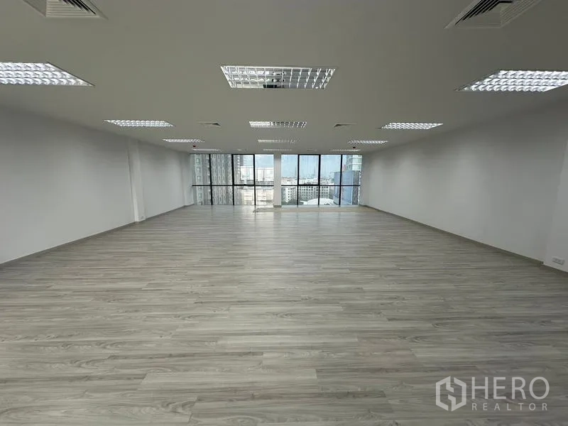 Office Space for rent - Spacious office floor featuring floor-to-ceiling windows, suspended ceiling lights and skyline views