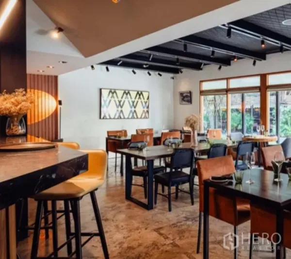 Retail Space for rent in Yan Nawa, Bangkok - Warm dining room with bar seating, modern ceiling lights and large windows in a Bangkok restaurant space.