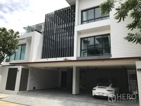 独立式住宅 出租在Bang Kapi, Bangkok - 三层现代独栋别墅外立面，大窗与垂直遮阳，带有覆盖车位